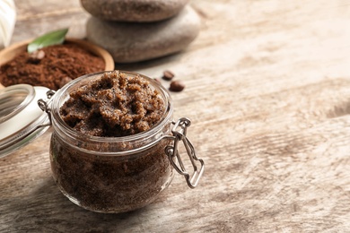 Photo of Jar with handmade natural body scrub on wooden background