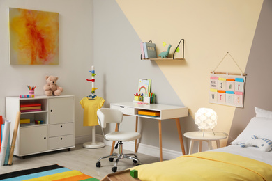 Stylish child room interior with comfortable bed and desk