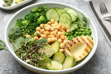 Healthy meal. Tasty vegetables and chickpeas in bowl on grey table, closeup