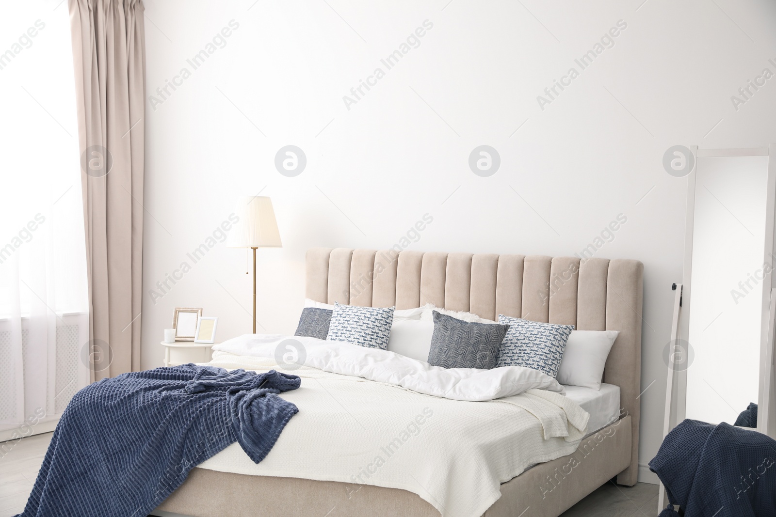 Photo of Comfortable bed with pillows in room. Stylish interior design