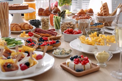 Photo of Variety of snacks on wooden table in buffet style indoors