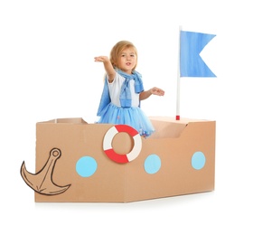 Photo of Cute little girl playing with cardboard ship on white background