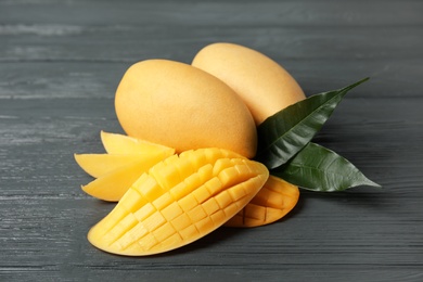 Composition with ripe mango on wooden table