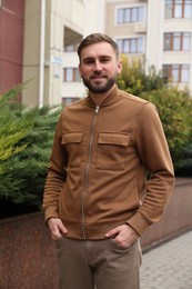 Photo of Handsome man wearing stylish clothes on city street. Autumn walk