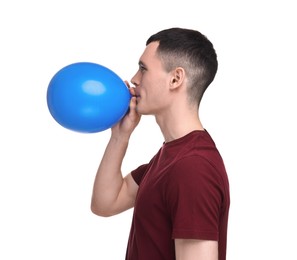 Photo of Young man inflating light blue balloon on white background