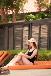 Photo of Beautiful young woman in swimsuit at resort