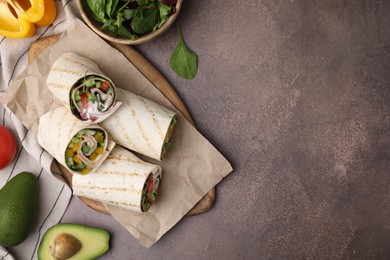 Photo of Delicious sandwich wraps with fresh vegetables on grey table, flat lay. Space for text