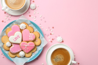 Photo of Romantic breakfast with heart shaped cookies and cups of coffee on color background, flat lay. Space for text