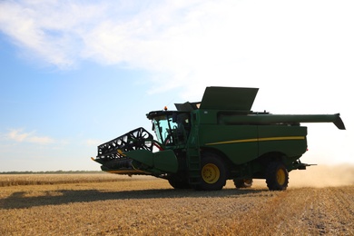 Photo of Modern combine harvester in field. Agricultural industry