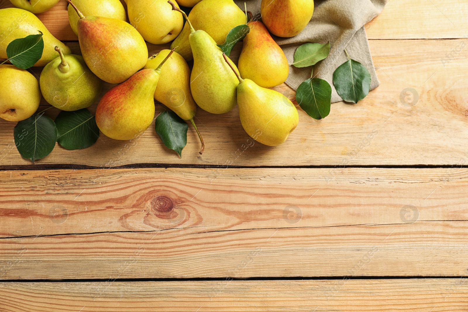 Photo of Ripe pears on wooden background, top view. Space for text