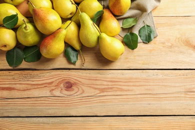 Ripe pears on wooden background, top view. Space for text