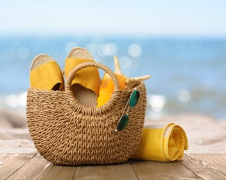 Image of Bag with sunscreen and accessories on sunny ocean beach. Summer vacation