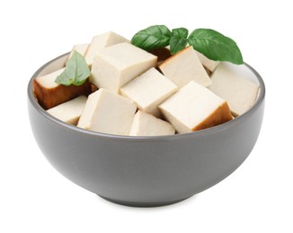 Photo of Bowl of delicious smoked tofu cubes with basil isolated on white