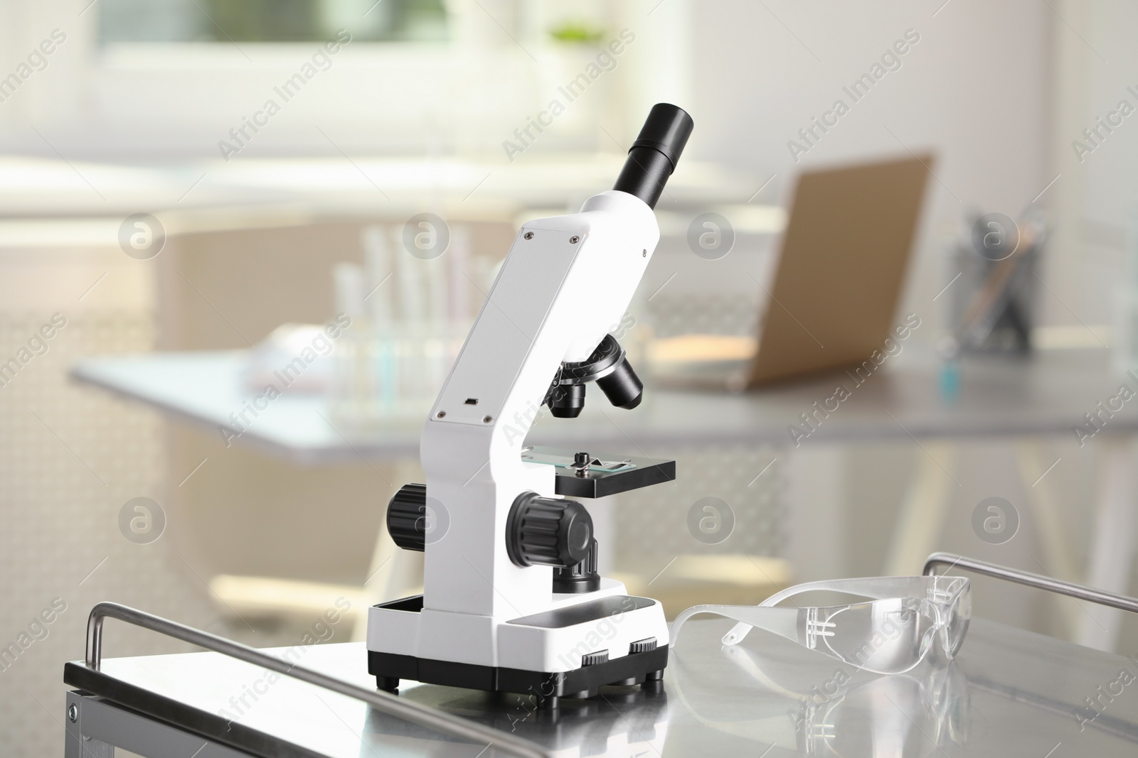 Photo of Modern medical microscope on metal table in laboratory