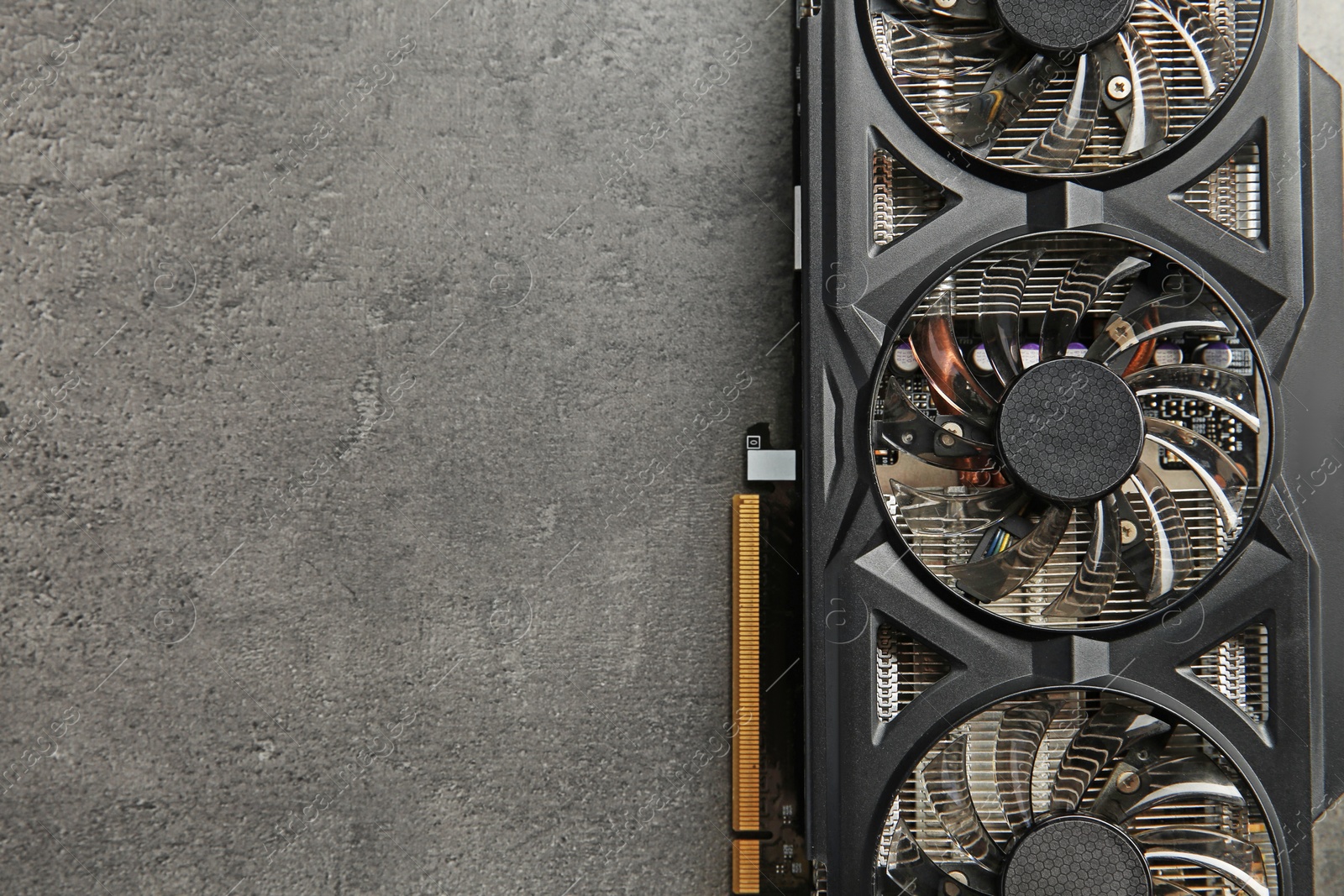 Photo of One computer graphics card on grey textured table, top view. Space for text