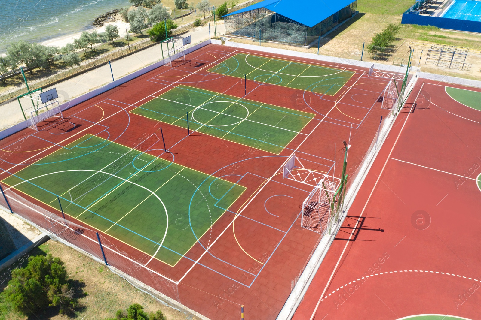 Image of Outdoor sports complex near sea on sunny day, aerial view