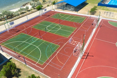 Outdoor sports complex near sea on sunny day, aerial view
