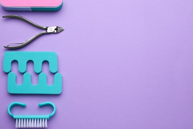 Set of pedicure tools on violet background, flat lay. Space for text