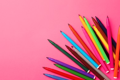 Photo of Many bright markers on pink background, flat lay. Space for text