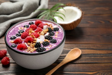 Photo of Delicious acai smoothie with fruits served on wooden table, closeup