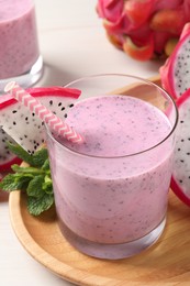 Photo of Delicious pitahaya smoothie, mint and fresh fruits on white wooden table, closeup