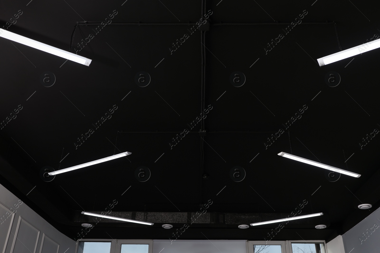 Photo of Black ceiling with modern lighting in office