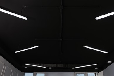 Photo of Black ceiling with modern lighting in office