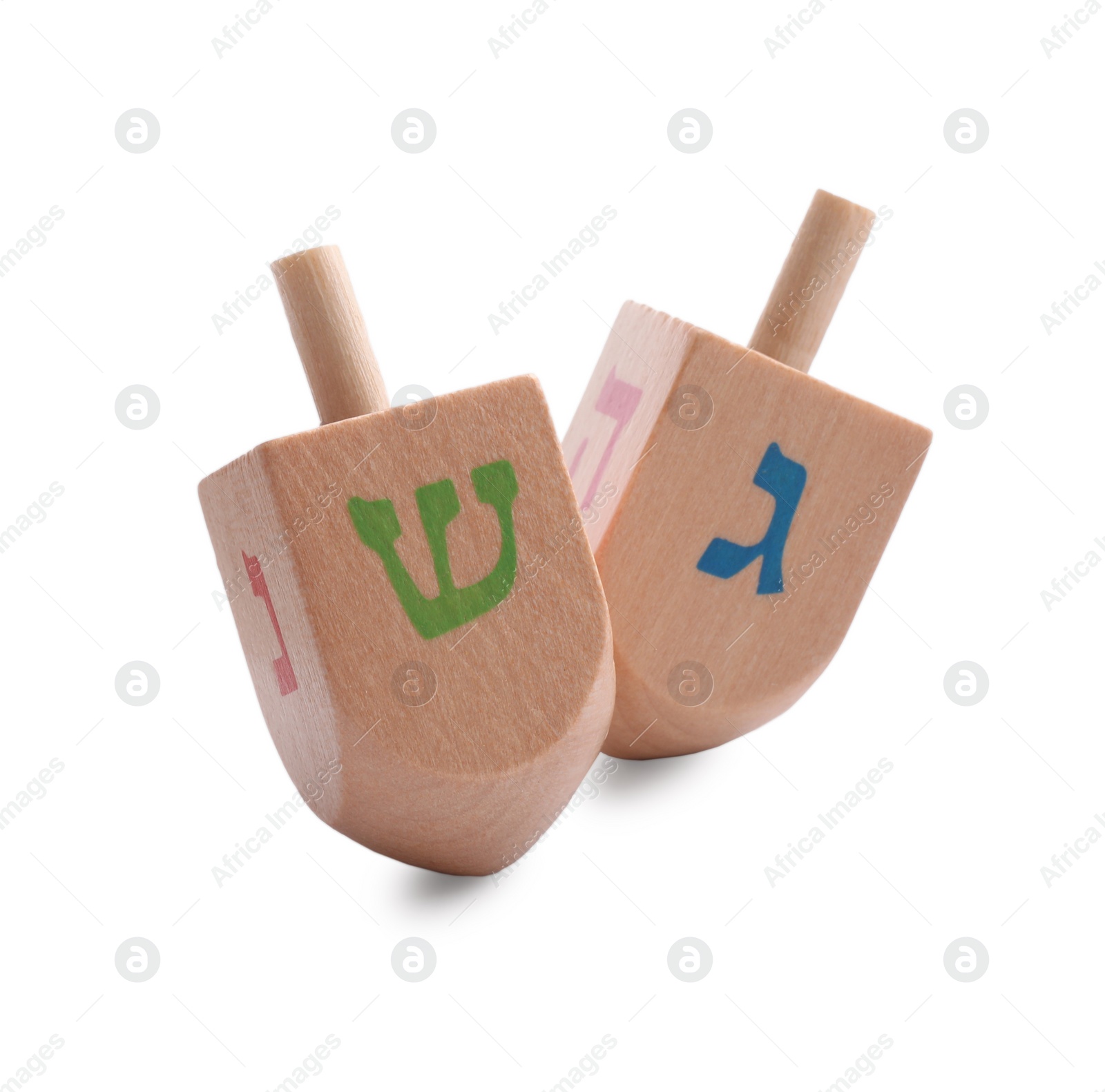 Photo of Wooden dreidels isolated on white. Traditional Hanukkah game