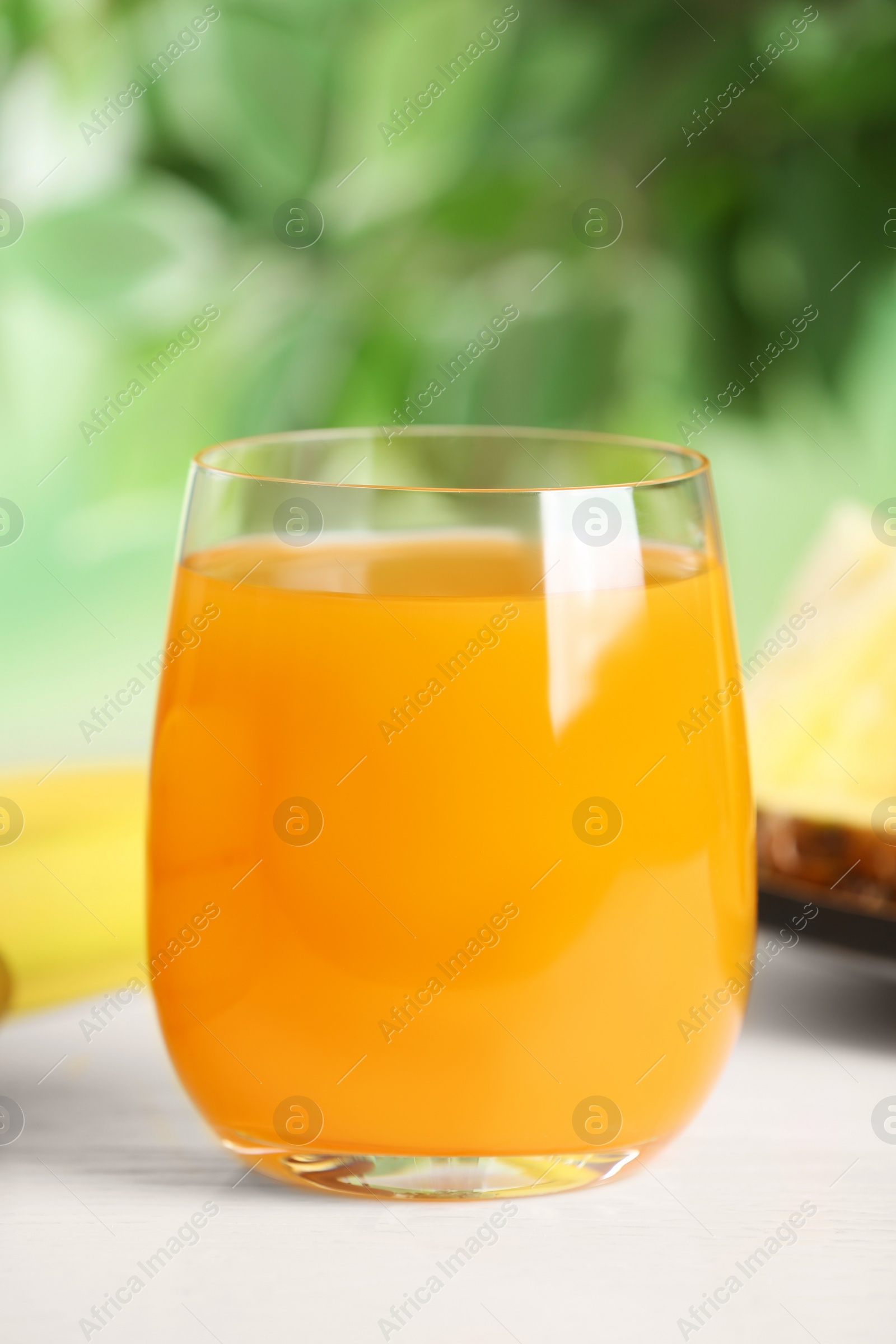 Photo of Yummy juice in glass on white table, closeup