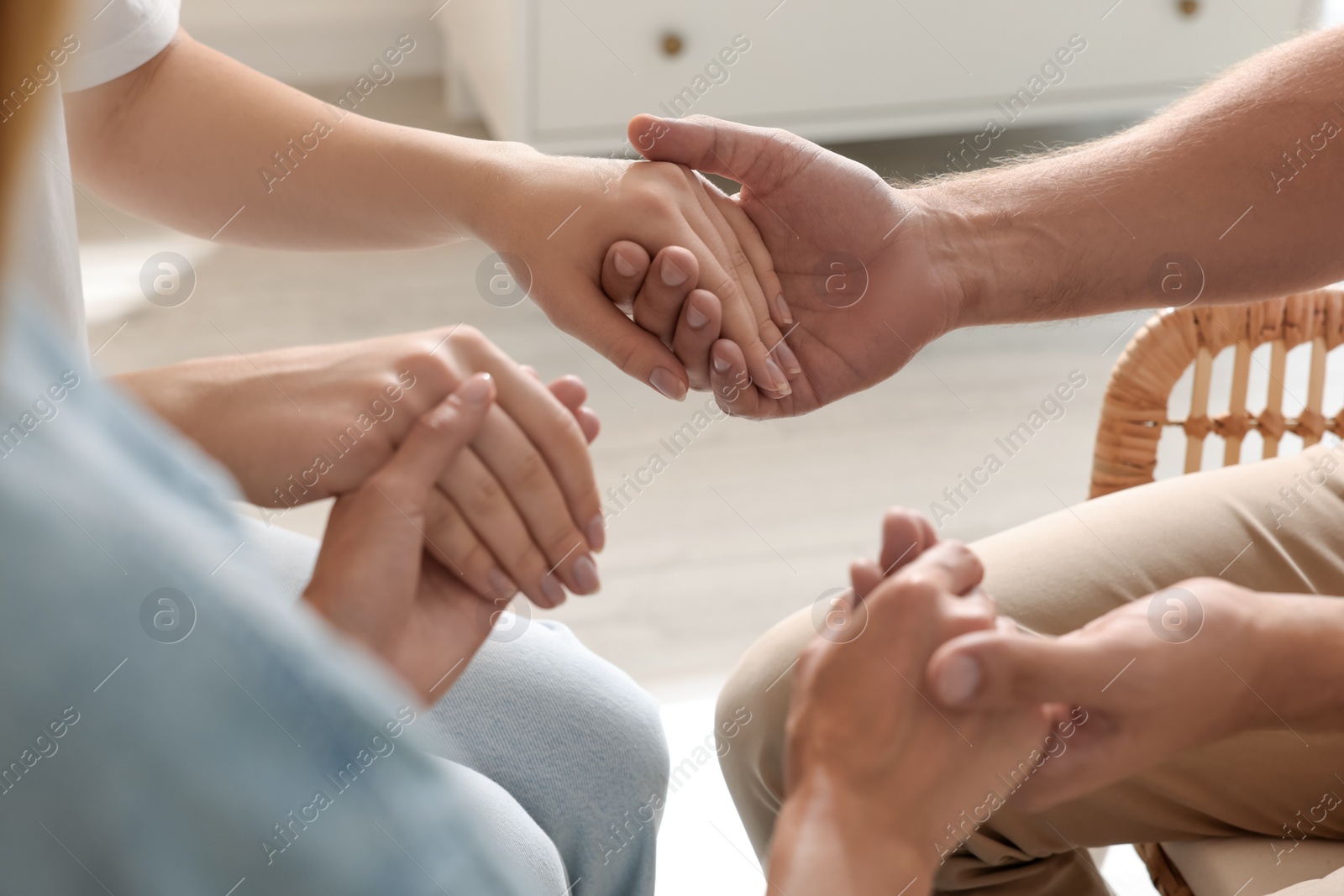 Photo of Group of religious people holding hands and praying together indoors, closeup