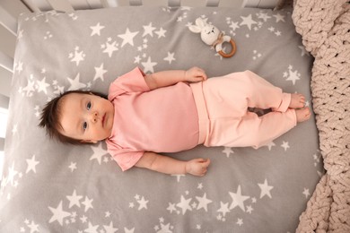 Photo of Time to sleep. Cute little baby lying in crib, top view