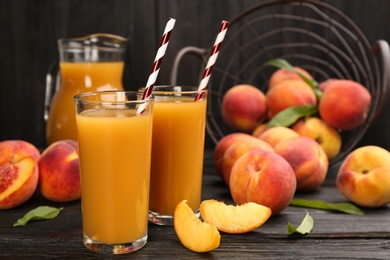Photo of Natural peach juice and fresh fruits on black wooden table
