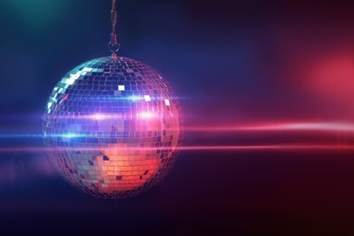 Photo of Shiny bright disco ball on dark background
