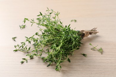 Bunch of aromatic thyme on wooden table, closeup