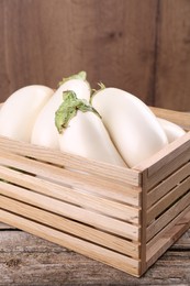 Photo of Fresh white eggplants in crate on wooden table