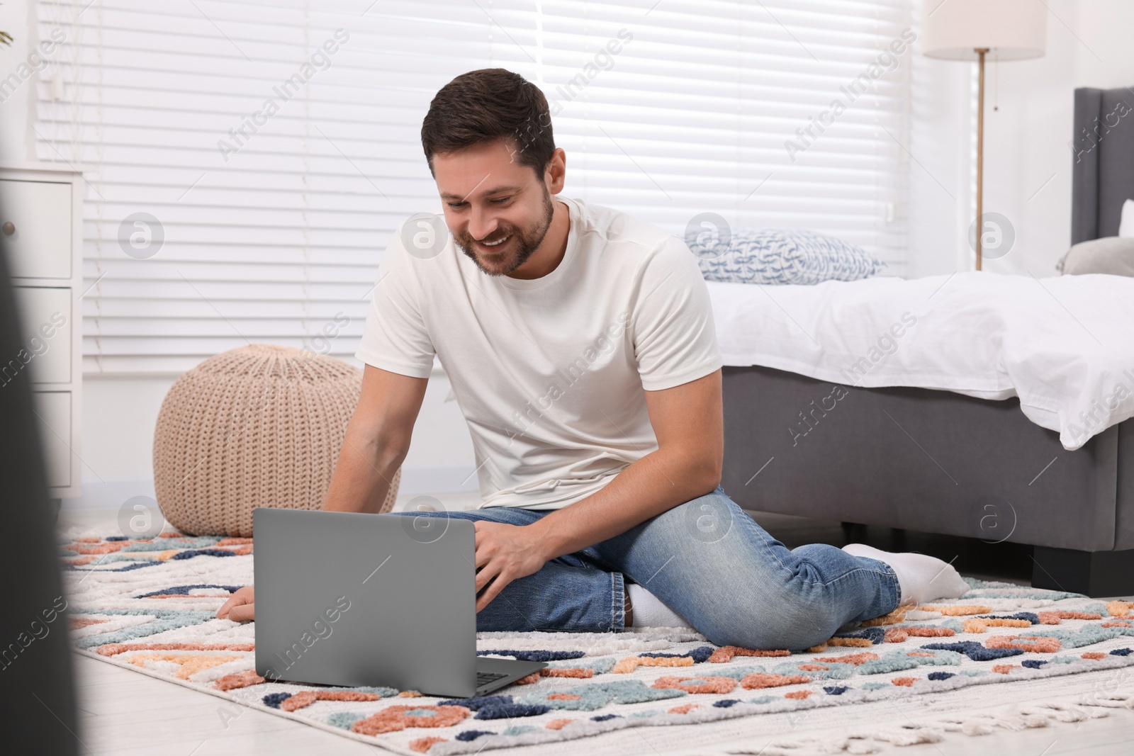 Photo of Happy man having video chat via laptop at home