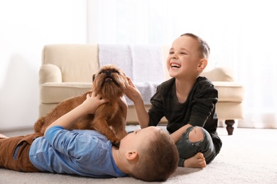 Portrait of cute boys with funny Brussels Griffon dog at home. Loyal friends