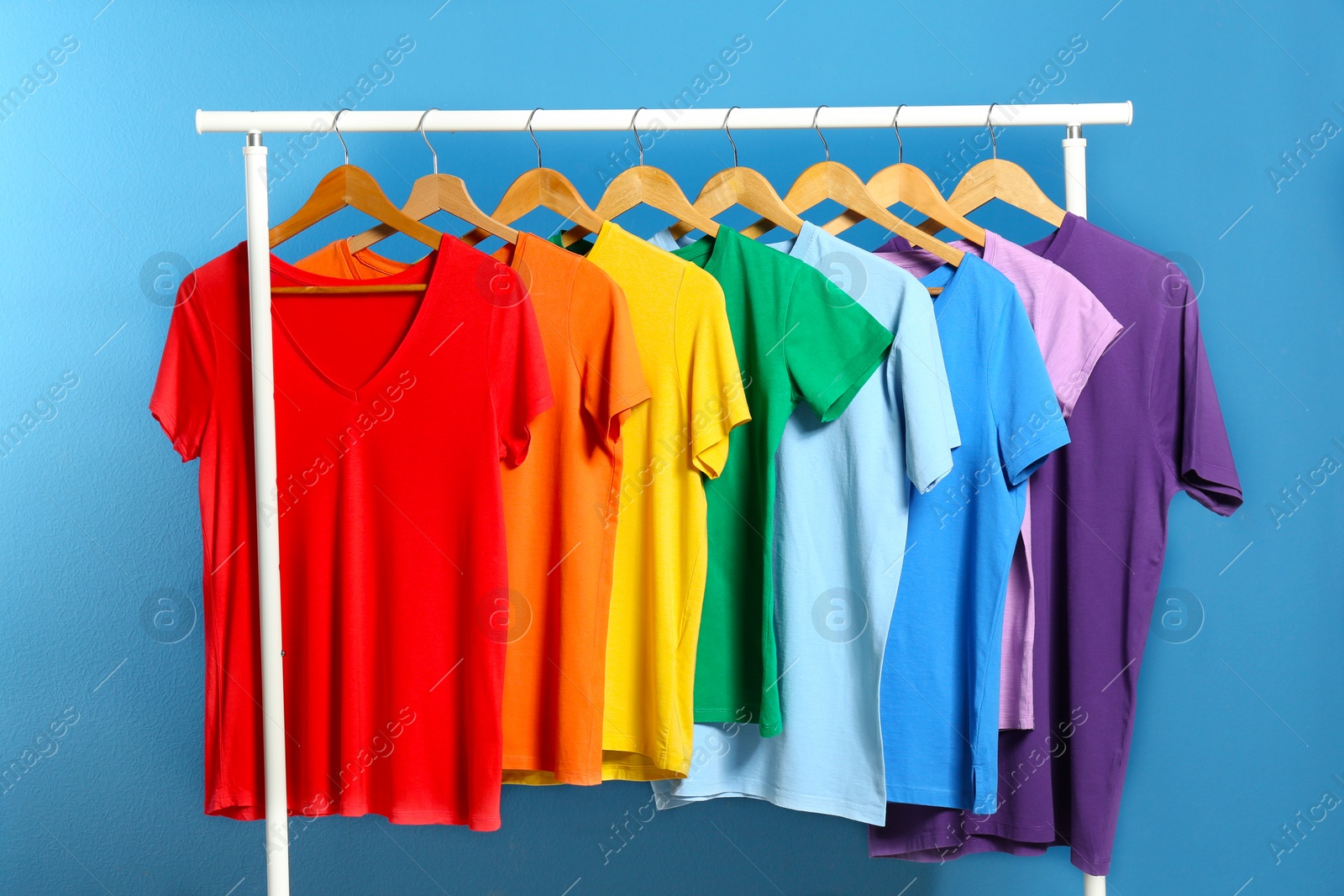 Photo of Bright clothes on blue background. Rainbow colors