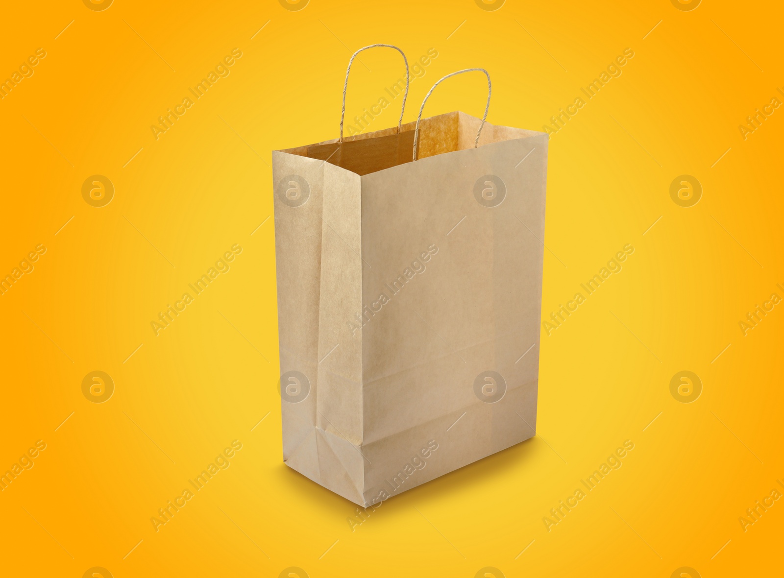 Image of Kraft paper bag on yellow background. Mockup for design