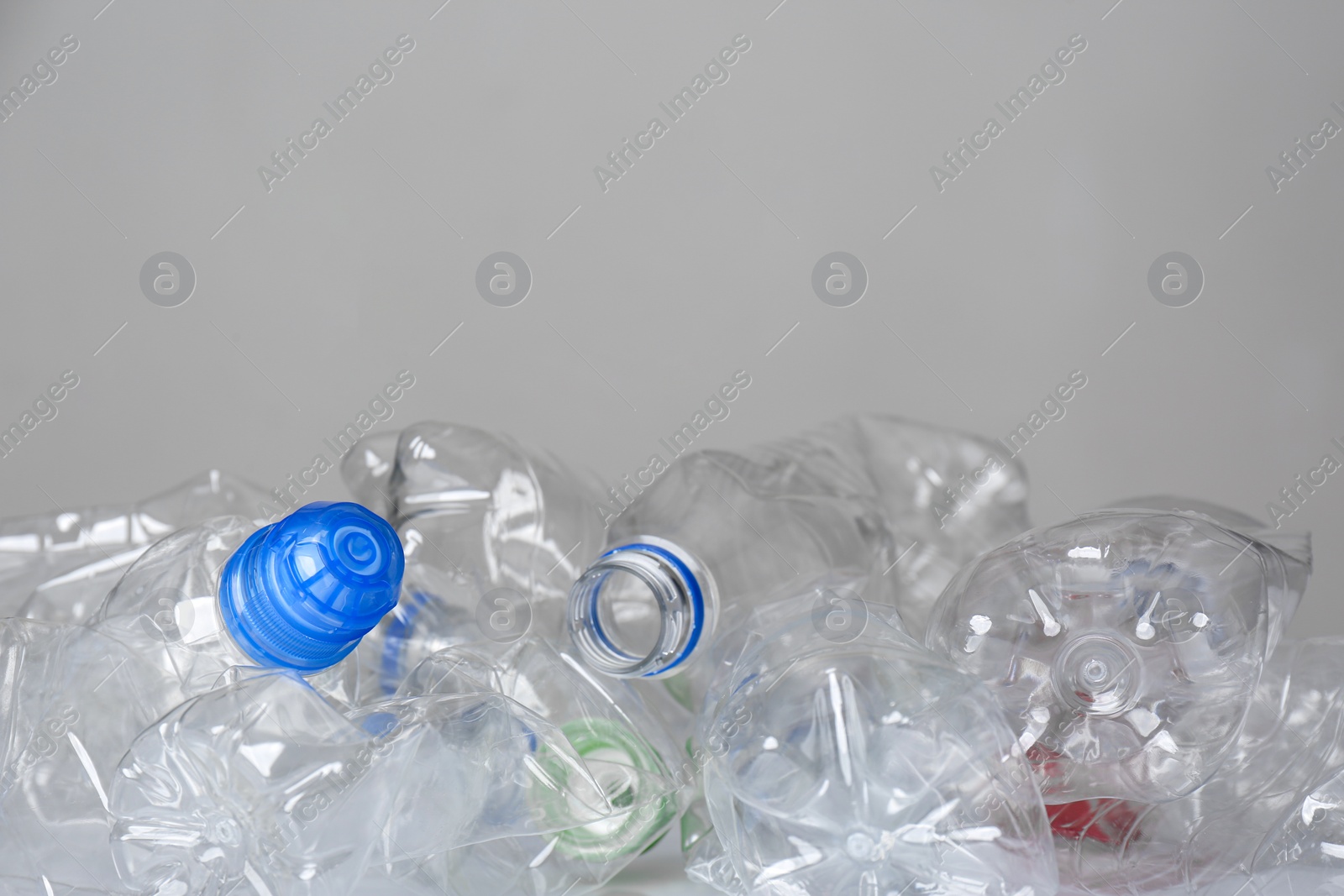 Photo of Many used plastic bottles against light background, space for text. Recycle concept