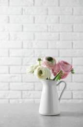 Photo of Vase with beautiful ranunculus flowers on table