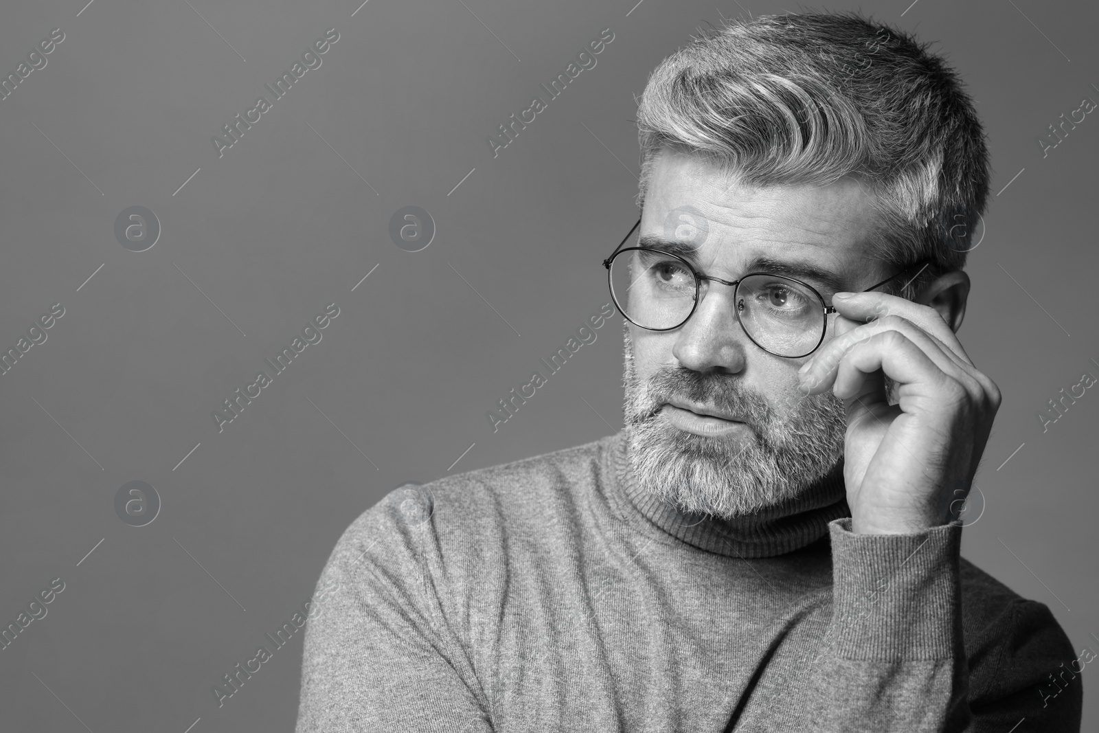 Photo of Portrait of handsome man on grey background, space for text. Black and white effect