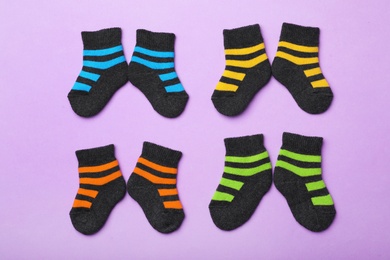 Photo of Cute child socks on color background, flat lay