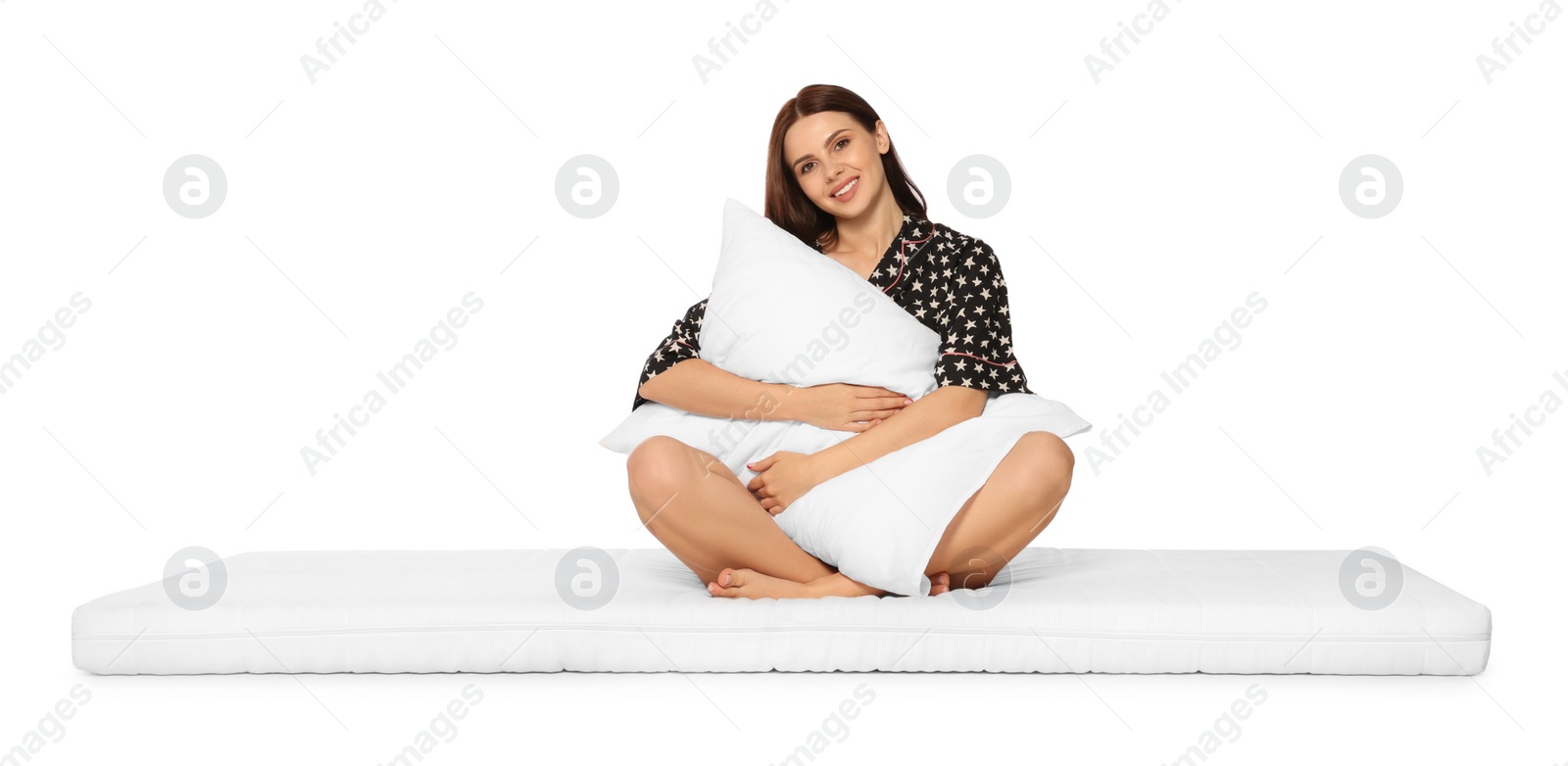 Photo of Young woman on soft mattress holding pillow against white background