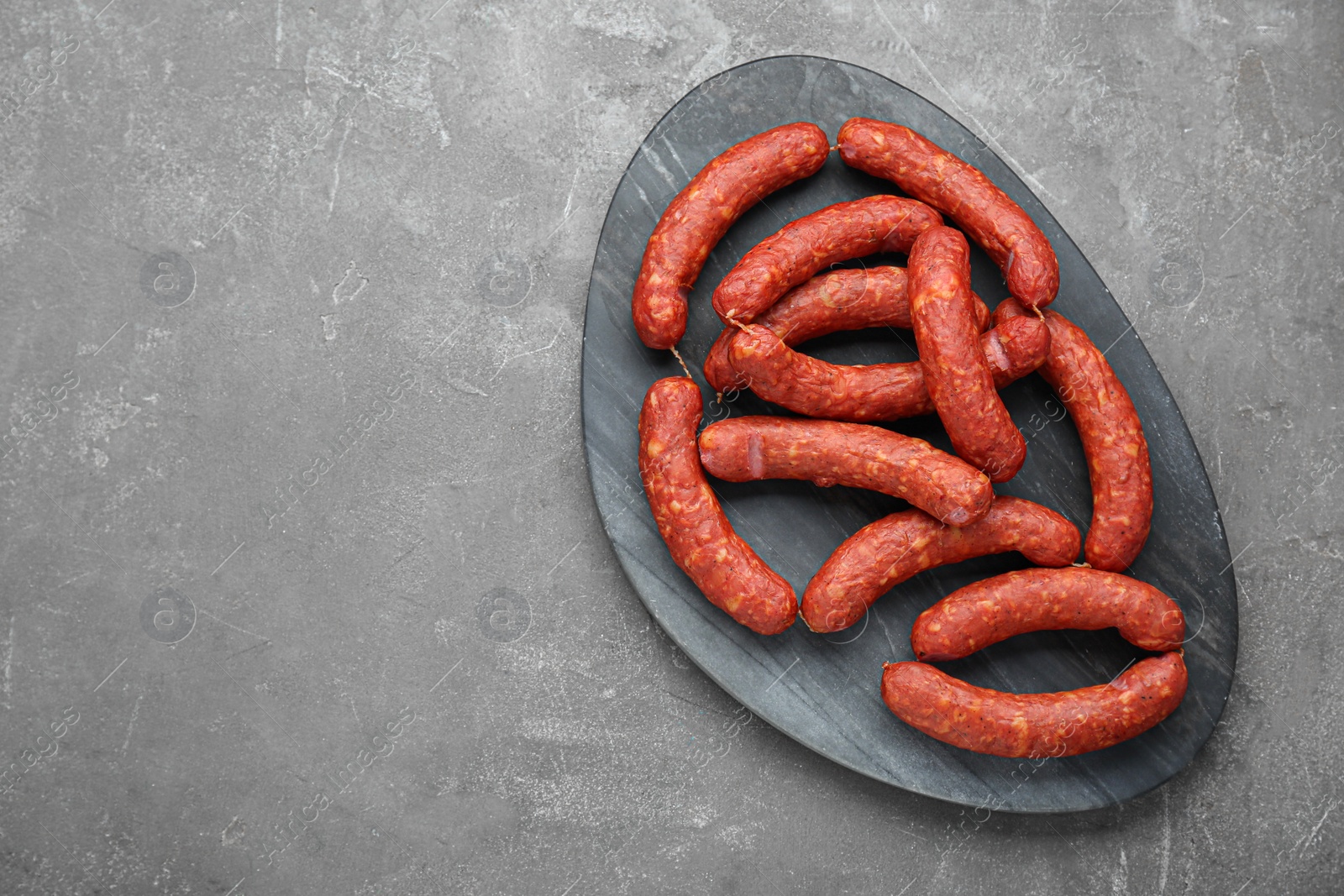 Photo of Delicious sausages on grey table, top view. Space for text