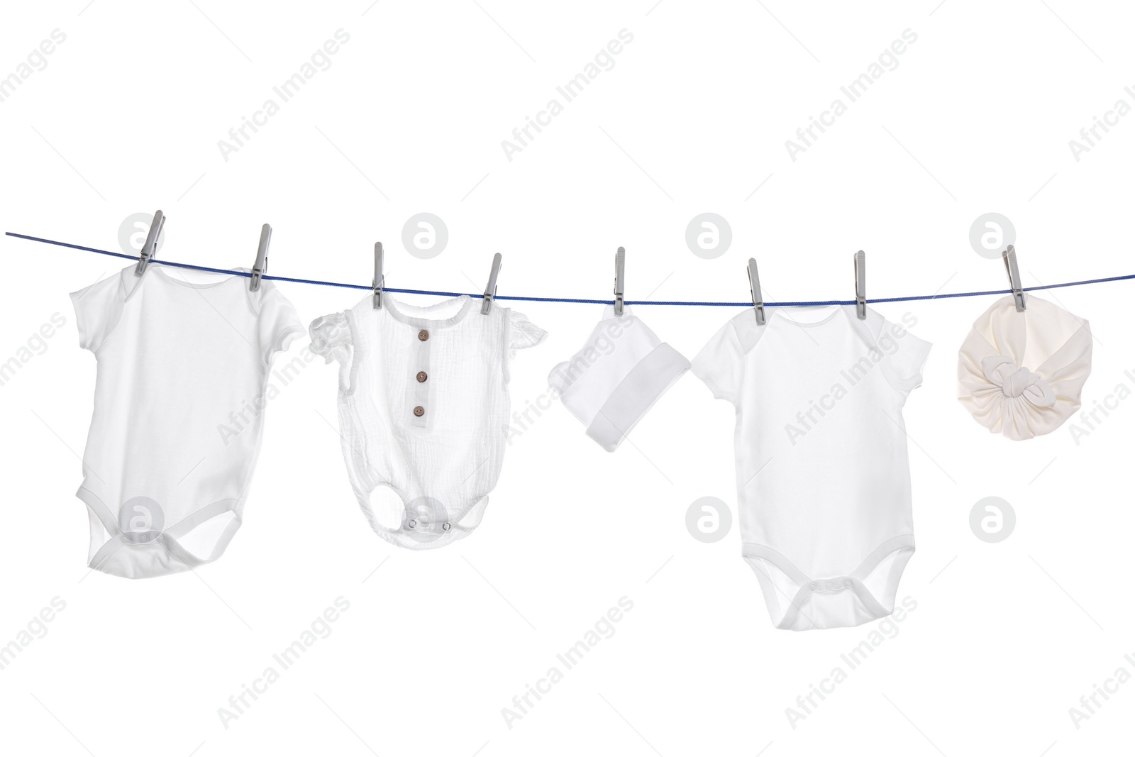 Photo of Different baby clothes drying on laundry line against white background