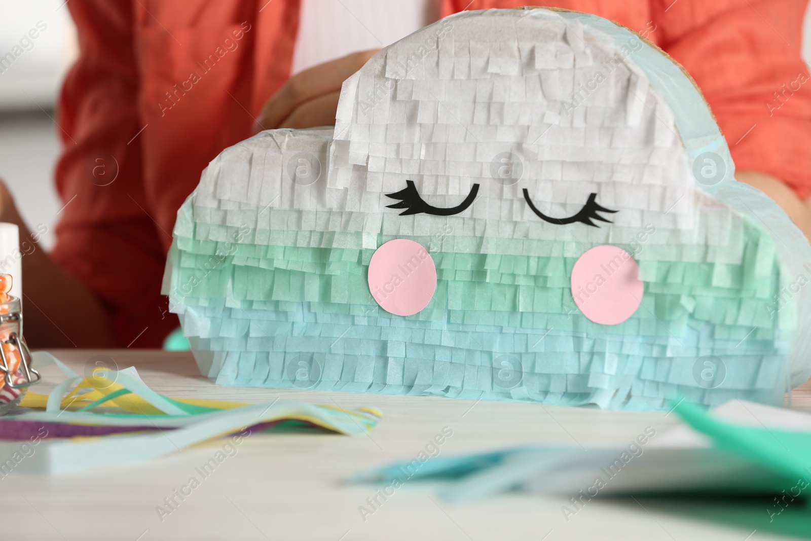 Photo of Woman making cardboard cloud at white wooden table, closeup. Pinata diy