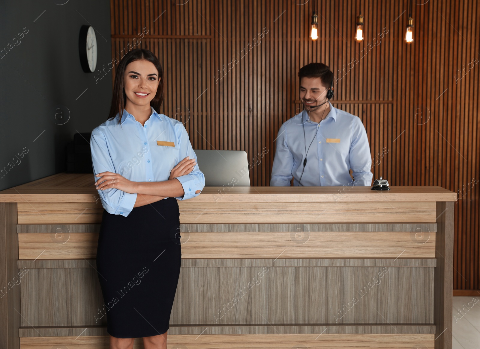 Photo of Receptionist at desk with colleague in lobby