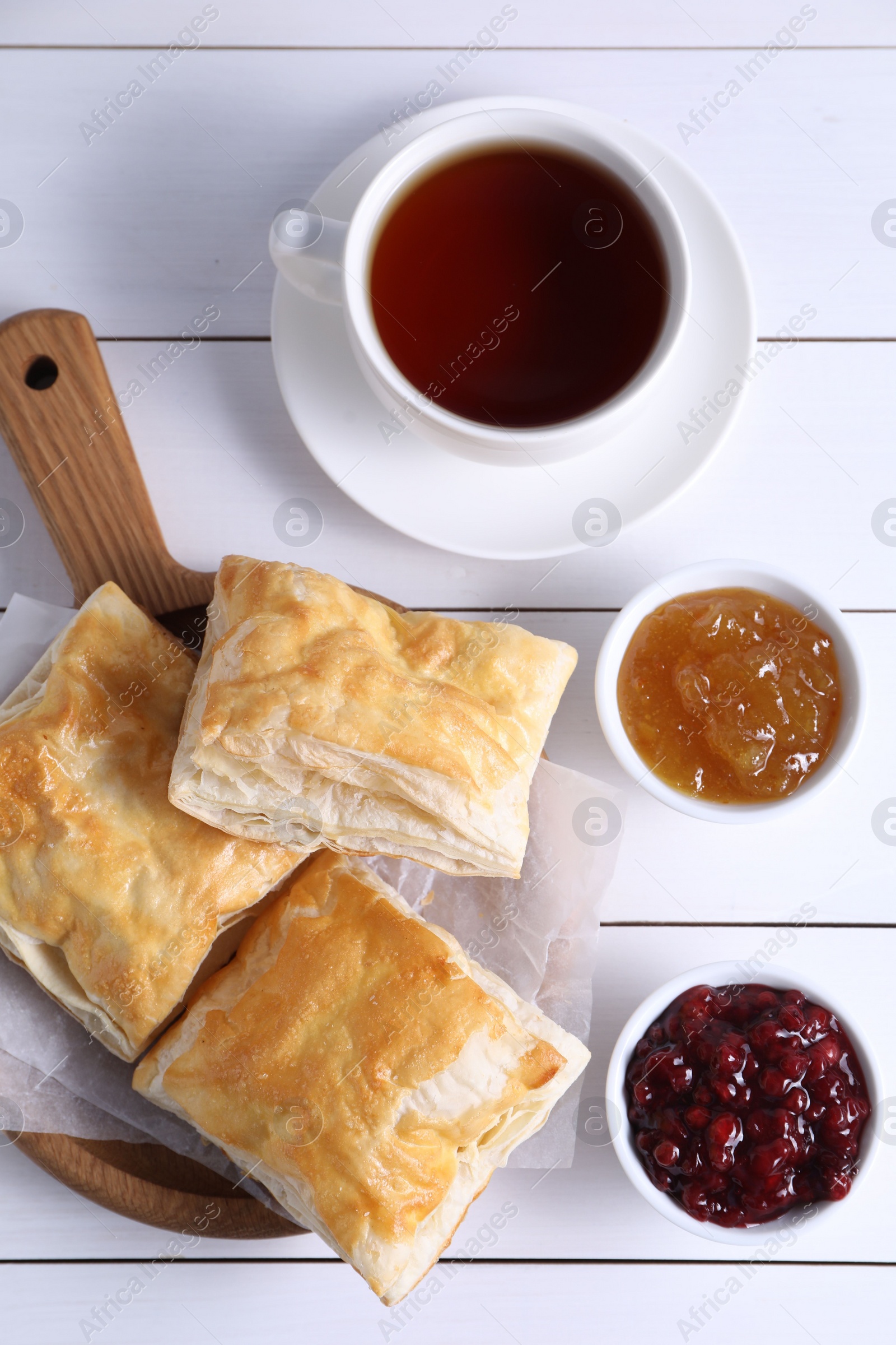 Photo of Delicious puff pastry served on white wooden table, flat lay