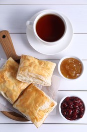 Delicious puff pastry served on white wooden table, flat lay